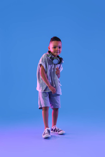 Cute dancing African-American boy on color background - Фото, изображение