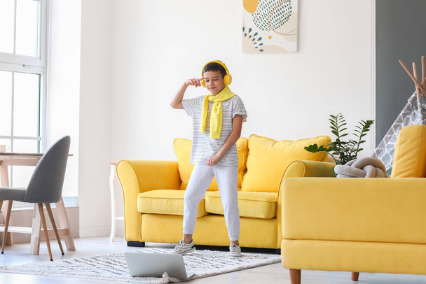 mignon petit garçon avec ordinateur portable apprendre à danser à la maison - Photo, image