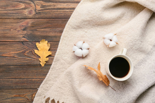 Flores de algodón, bufanda cálida y taza de café sobre fondo de madera - Foto, Imagen