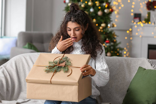 mujer feliz abriendo regalo de Navidad en casa - Foto, Imagen