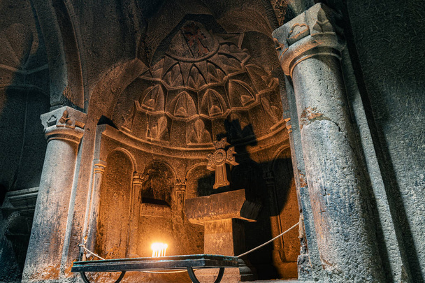 Mum yakan bir sunak ve Ermenistan 'daki Geghard Kilisesi ve manastırında bir taş haç. - Fotoğraf, Görsel