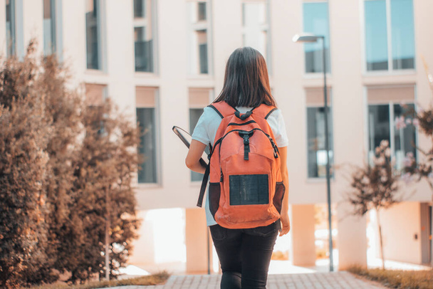 Estudante do campus universitário caminhando pelas instalações da faculdade com mochila - Foto, Imagem