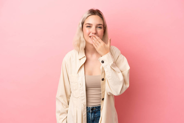 Young caucasian woman isolated on pink background happy and smiling covering mouth with hand - Foto, Imagem
