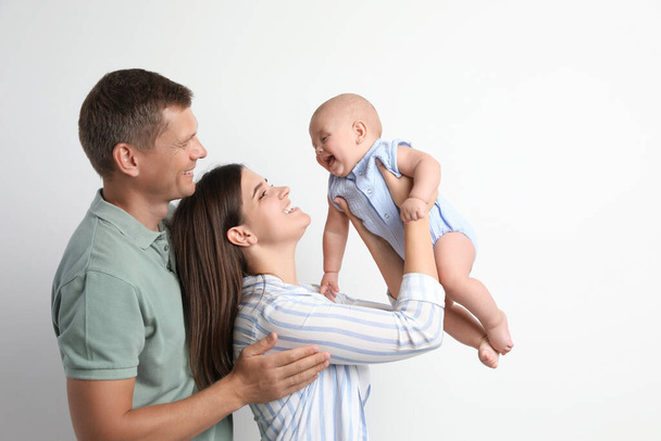 Portrait of happy family with their cute baby on white background - Zdjęcie, obraz