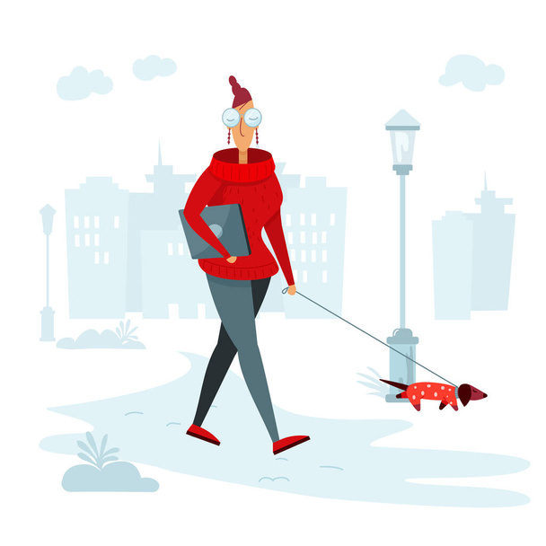 Una mujer camina con un perro salchicha y lleva un portátil debajo de su brazo para trabajar en el parque. - Vector, imagen
