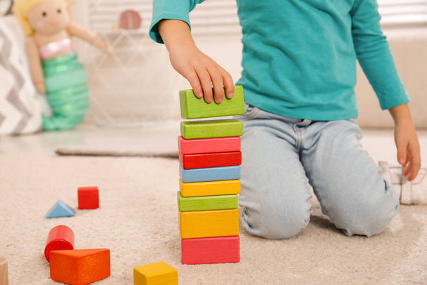 Cute little girl playing with colorful building blocks at home, closeup - Photo, Image