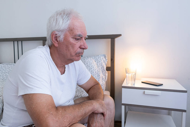 старик мужчина старший сидеть дома плоская кровать, плохой сон печальный несчастный одинокий брошенный вдовец. - Фото, изображение