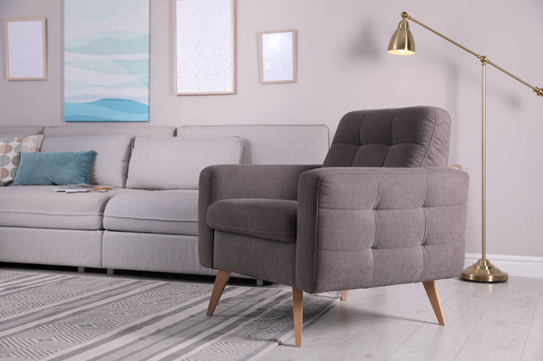Stylish living room interior with comfortable armchair and sofa - Фото, зображення