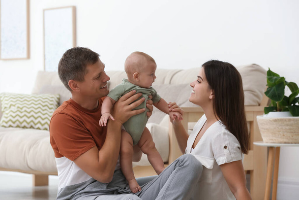 Portrait of happy family with their cute baby at home - Foto, Imagem