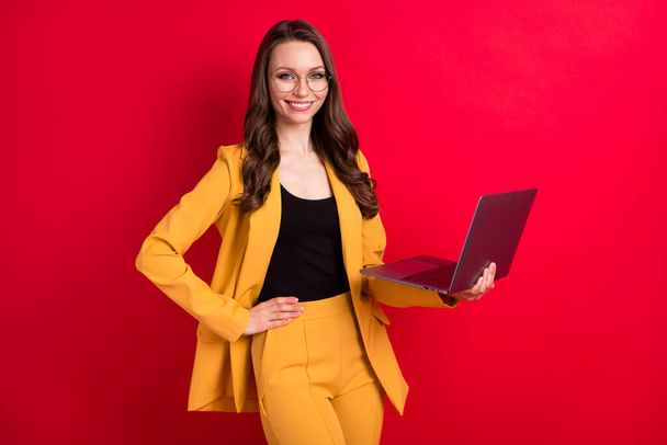 Portrait of attractive cheerful lady using laptop e-commerce company isolated over bright red color background - Zdjęcie, obraz
