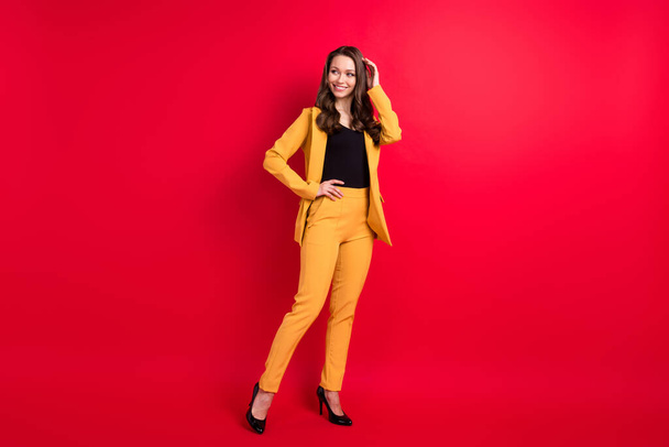 Full length body size view of attractive cheerful fashionable girl posing looking asside isolated over bright red color background - Foto, imagen