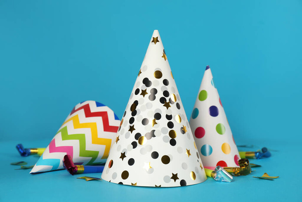 Colorful party hats and festive items on light blue background - Фото, изображение