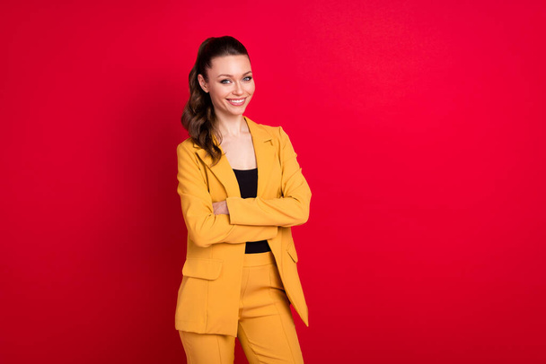 Photo of sweet charming young lady dressed yellow blazer arms crossed empty space smiling isolated red color background - Valokuva, kuva