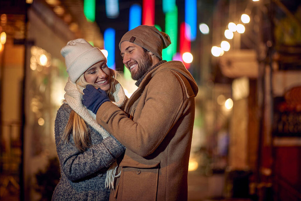 Young smiling man and woman walking in winter city - Foto, immagini