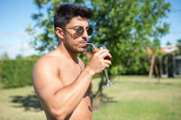 Good-looking man drinking bright cocktail - Fotoğraf, Görsel