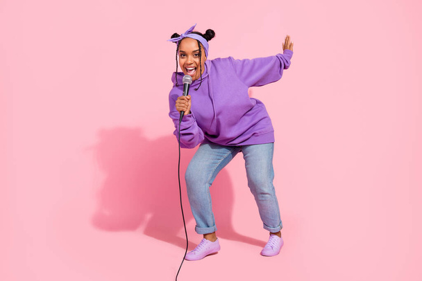 Photo of beautiful funky afro woman wear purple hoodie buns dancing singing karaoke smiling isolated pink color background - Foto, immagini