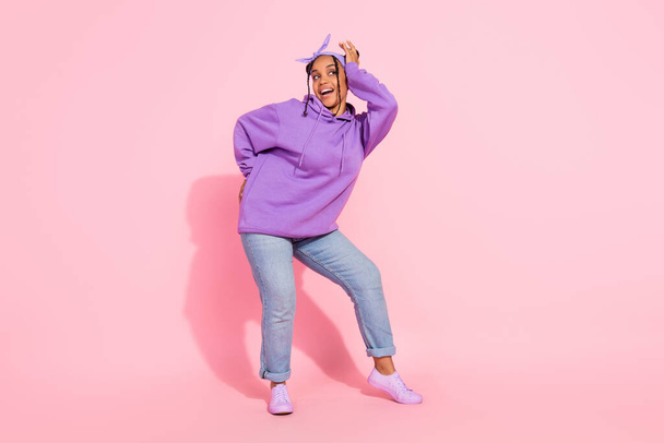 Photo of attractive pretty afro woman wear purple hoodie buns dancing smiling isolated pink color background - Φωτογραφία, εικόνα