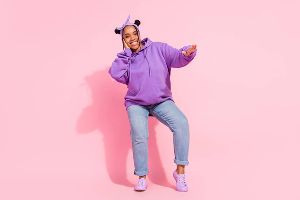 Photo of funny beautiful african lady dressed violet sweatshirt buns smiling dancing isolated pink color background - Fotó, kép