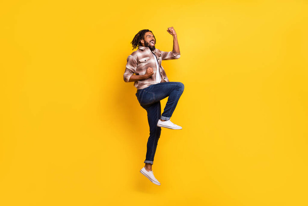 Full length body size photo of man jumping high gesturing like winner overjoyed isolated on vivid yellow color background - Foto, Imagem