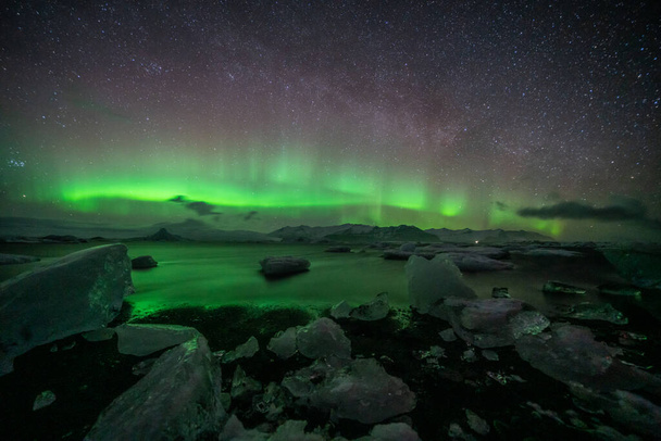 Ongelooflijke Aurora Borealis activiteit boven de kust in IJsland - Foto, afbeelding