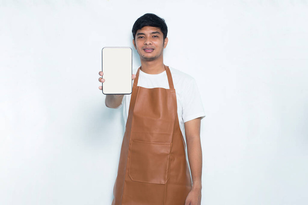 feliz alegre joven asiático hombre barista barman o camarera demostrando móvil celular en blanco fondo - Foto, Imagen