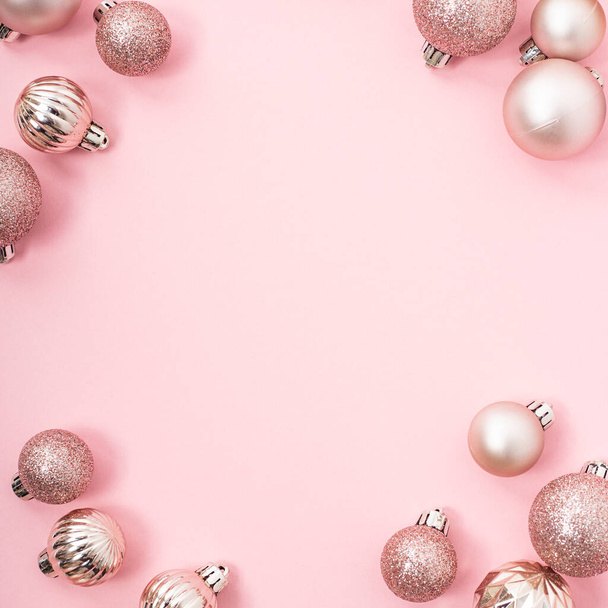 Decoratieve kerstballen, lege ruimte voor tekst op een roze achtergrond. Bovenaanzicht, vlak lay - Foto, afbeelding