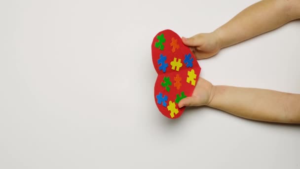 Child extends his hand to the child with autism syndrome and firmly squeezes his wrist as a sign of support. Teach kids to be kind, responsive and come to the aid of those in need. Autism day concept - Footage, Video