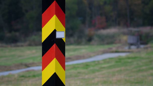 STAAT BORDER POLE - De Duitse grens is gemarkeerd met palen in nationale kleuren - Foto, afbeelding