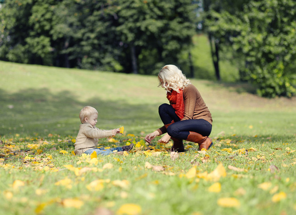 Mother and child playing in autumn park - Φωτογραφία, εικόνα