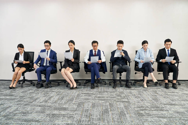 ομάδα ασιατικών επιχειρηματιών άνδρες και γυναίκες περιμένουν στην ουρά για συνέντευξη εργασίας - Φωτογραφία, εικόνα