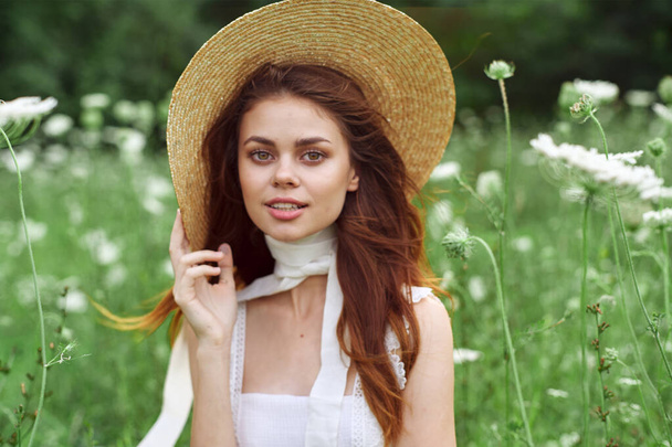 jolie femme en robe blanche et chapeau posant fleurs nature - Photo, image