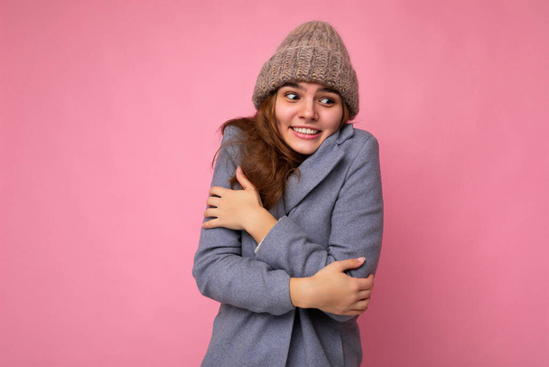 Όμορφη θετική ευτυχισμένη νεαρή μελαχρινή γυναίκα απομονωμένη πάνω από πολύχρωμο φόντο τοίχο φορώντας casual μοντέρνα ρούχα αισθάνονται ειλικρινή συναισθήματα κοιτάζοντας στο πλάι - Φωτογραφία, εικόνα