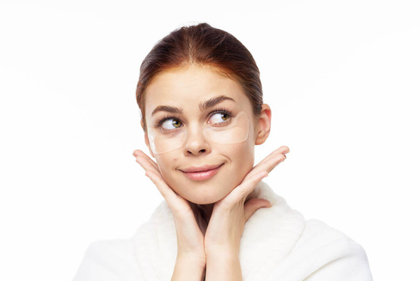 Woman in white robe posing fun skin care patches on face - Zdjęcie, obraz