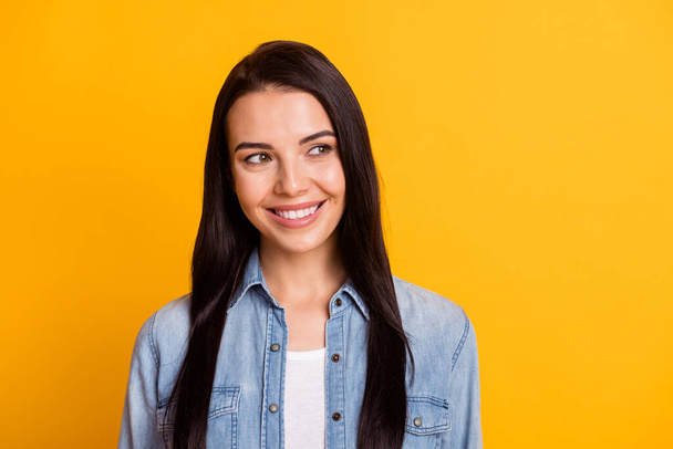 Portrait of nice optimistic brunette lady look empty space wear blue shirt isolated on bright yellow color background - Foto, Imagem