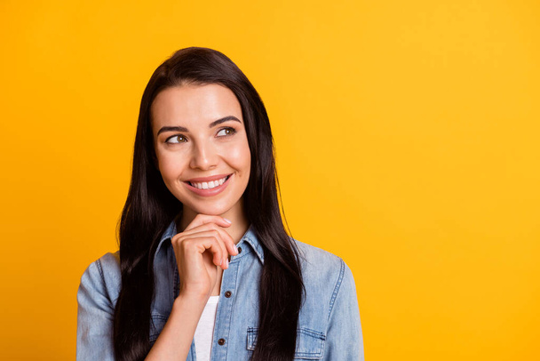 Portrait of adorable person hand on chin look interested empty space toothy smile isolated on yellow color background - Zdjęcie, obraz