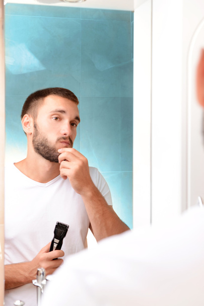 mladý muž holení jeho vousy v koupelně - Fotografie, Obrázek