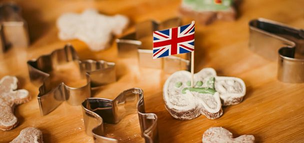 British holiday and Christmas baking concept. Union Jack flag of Great Britain and gingerbread men biscuits in the kitchen in England - Valokuva, kuva