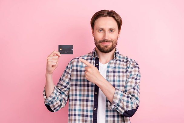 Photo of young man happy positive smile indicate finger credit card pay ad advice choice isolated over pink color background - Fotoğraf, Görsel