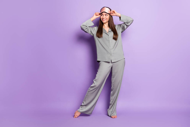 Longitud completa vista del tamaño del cuerpo de la encantadora chica alegre usar pijama posando buen pensamiento aislado sobre violeta color púrpura fondo - Foto, Imagen