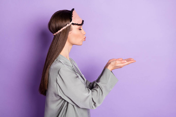 Профиль сторона фото флирта милая молодая женщина отправить воздушный поцелуй руки пустой пространство носить пижаму изолированы на фиолетовом фоне цвета - Фото, изображение