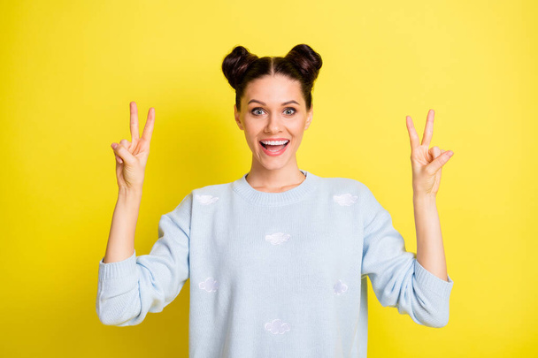 Photo of young pretty happy excited smiling positive girl showing b-sign wear pullover isolated on yellow color background - Photo, Image