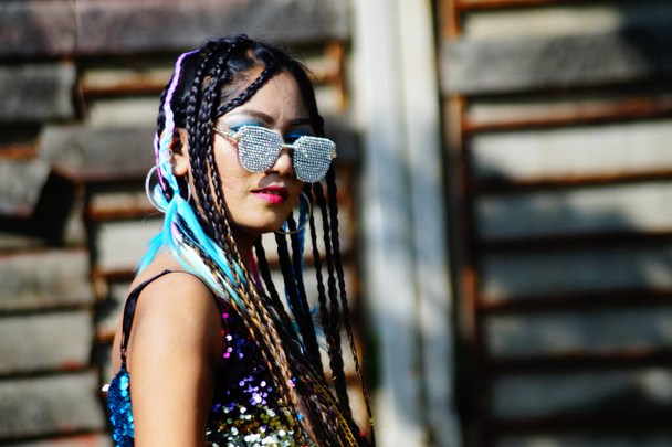 A stylish Indian female with dreadlocks and sunglasses posing at camera - Foto, immagini