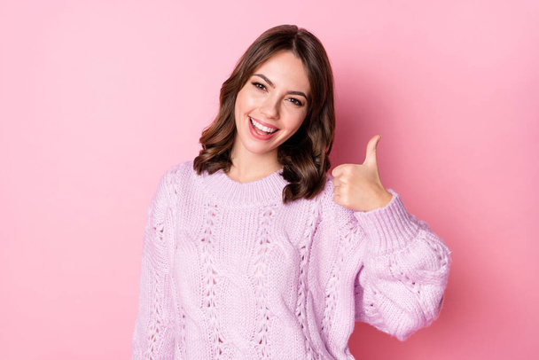 Portrait of pretty cheerful wavy-haired girl showing thumbup ad solution isolated over pink pastel color background - Fotó, kép