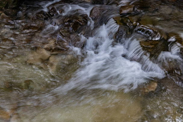 A beautiful view of spring water with rocks in a forest - Foto, immagini