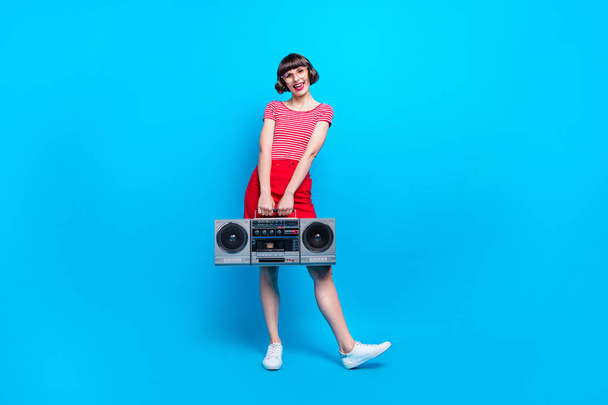 Plná délka tělo velikost fotografie dívka vedení retro magnetofon s úsměvem šťastný izolované živé modré barvy pozadí - Fotografie, Obrázek