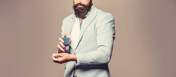 Perfume or cologne bottle and perfumery, cosmetics, scent cologne bottle, male holding cologne. Masculine perfume, bearded man in a suit. Male holding up bottle of perfume. Man perfume, fragrance - Foto, Bild