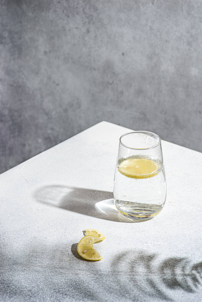 water with lemon on a gray background. High quality photo - Fotografie, Obrázek