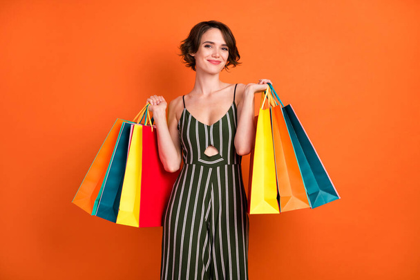 Φωτογραφία του νεαρού κοριτσιού ευτυχής θετικό χαμόγελο shopper μαύρο Παρασκευή πώληση τσάντες των πελατών απομονώνονται σε πορτοκαλί χρώμα φόντο - Φωτογραφία, εικόνα