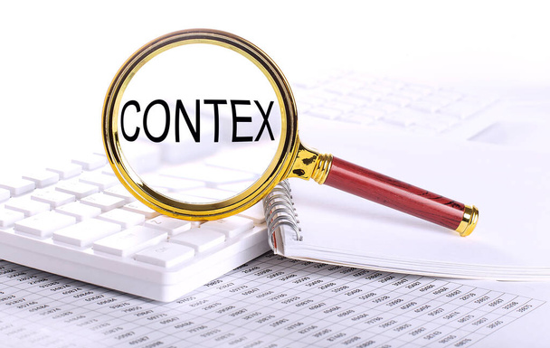 CONTEX λέξη μέσα από μεγεθυντικό φακό στο πληκτρολόγιο στο διάγραμμα - Φωτογραφία, εικόνα