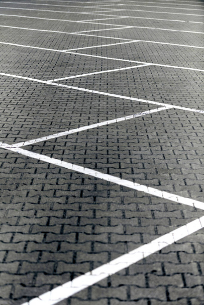 Segnaletica stradale di parcheggio su pavimentazione in mattoni senza auto. Linee di demarcazione bianca della superficie stradale nel parcheggio auto, posti auto gratuiti contrassegnati. Linee geometriche bianche che separano lo spazio - Foto, immagini